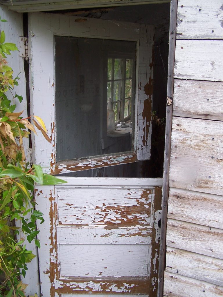 partially open door of a weathered cabin